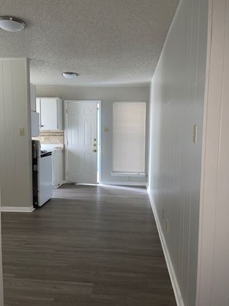 an empty kitchen with a wooden floor and a white door