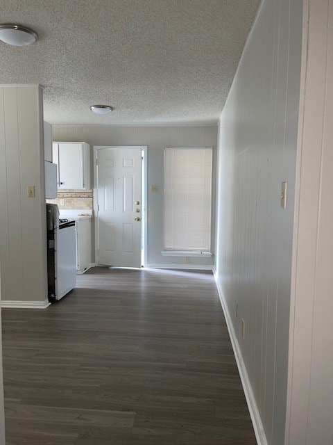 A long hallway with a white door at the end.