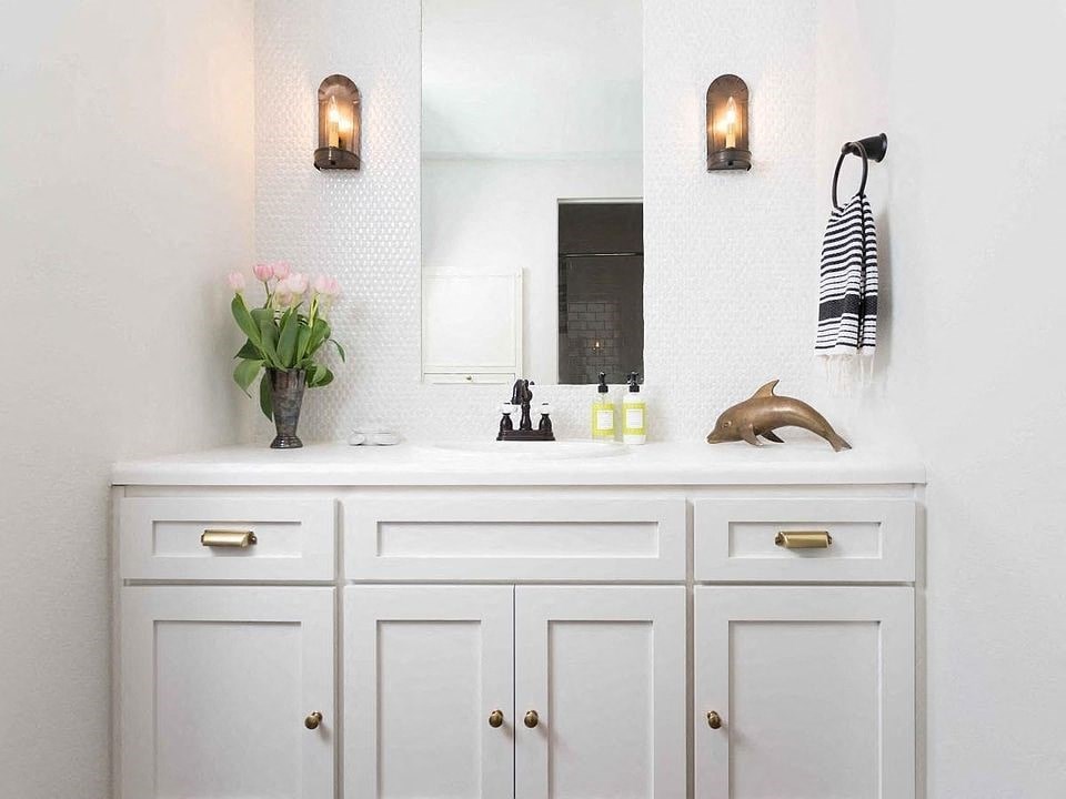 a white bathroom with a sink and a mirror