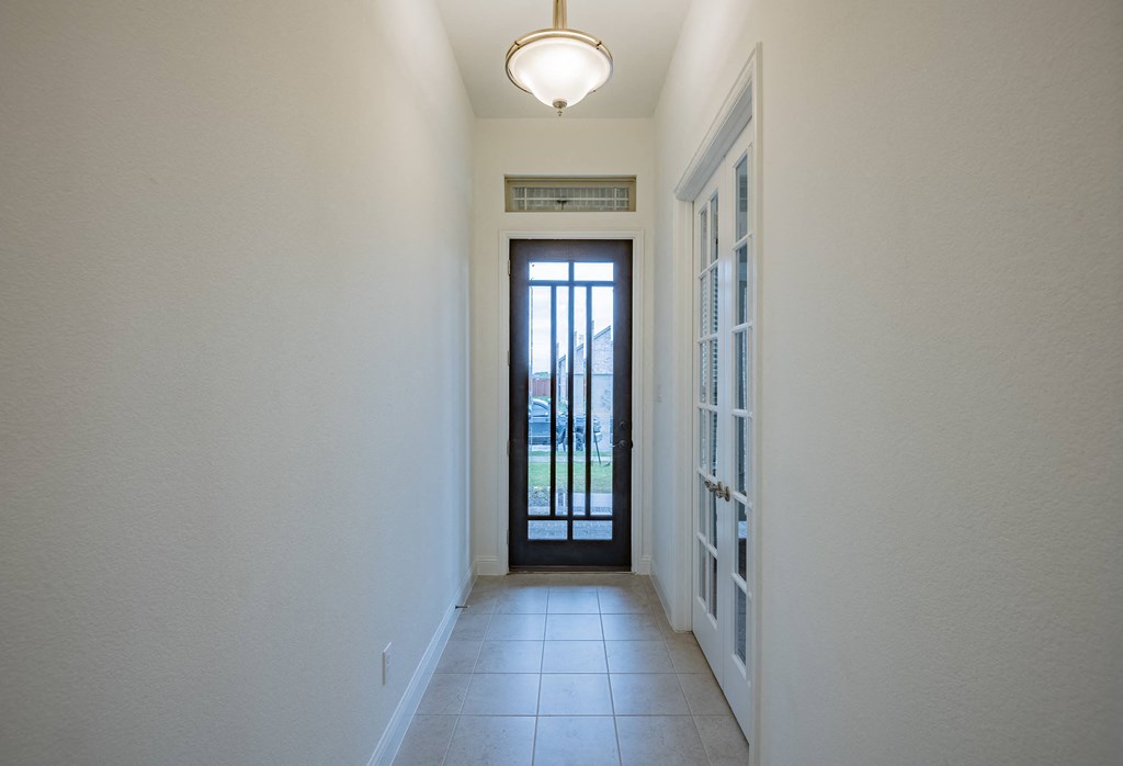 a long hallway with a door and a light on the ceiling