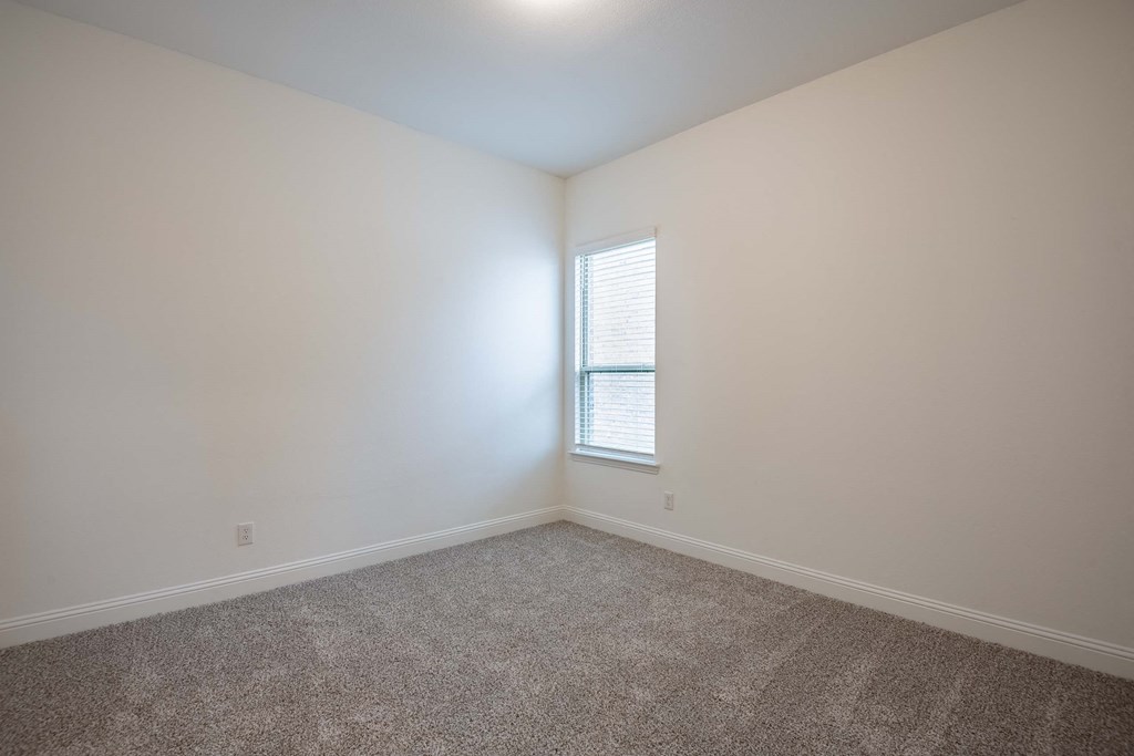a bedroom with white walls and a window