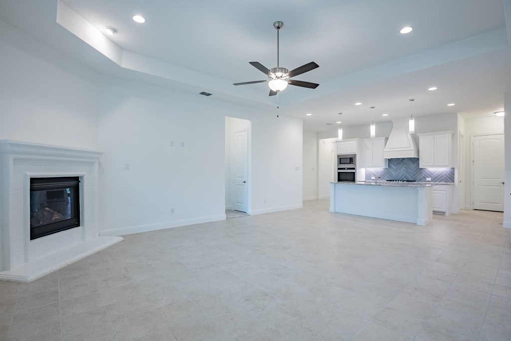 a large living room with a fireplace and a kitchen
