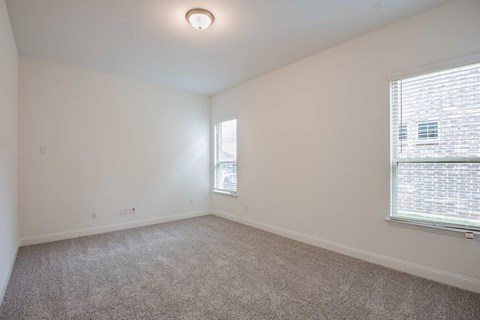 a spacious living room with a window and carpet