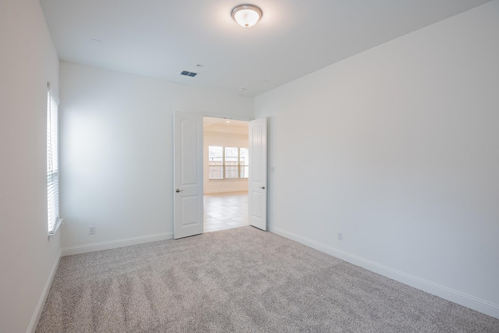 a empty living room with white walls and carpet