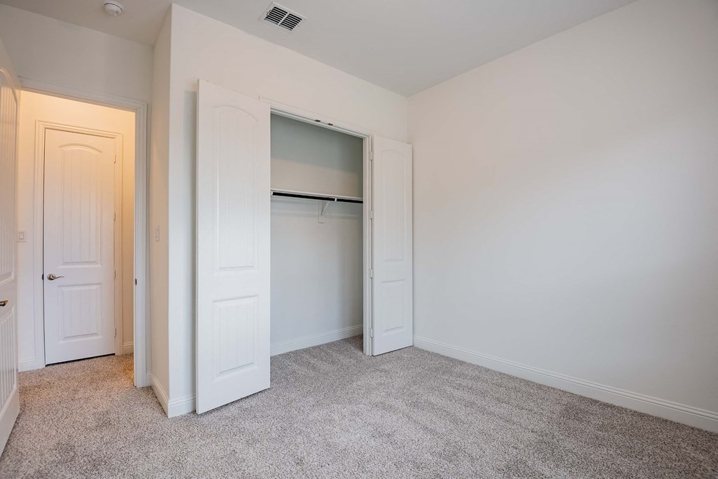 a bedroom with a closet and a door to a wardrobe