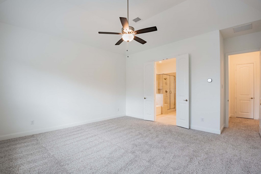 a living room with white walls and a ceiling fan