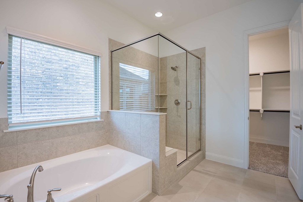 a bathroom with a tub and a shower and a window