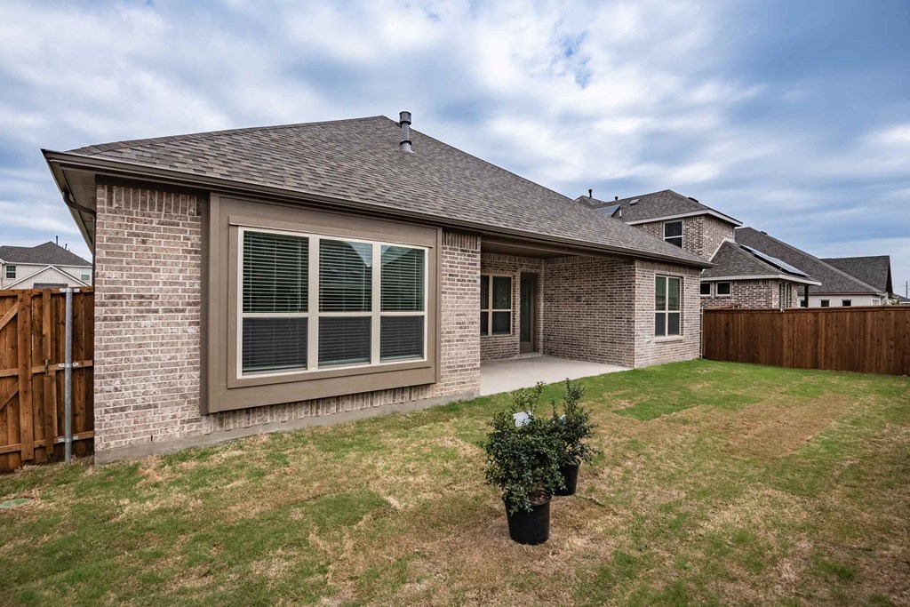 a brick house with a yard and a patio