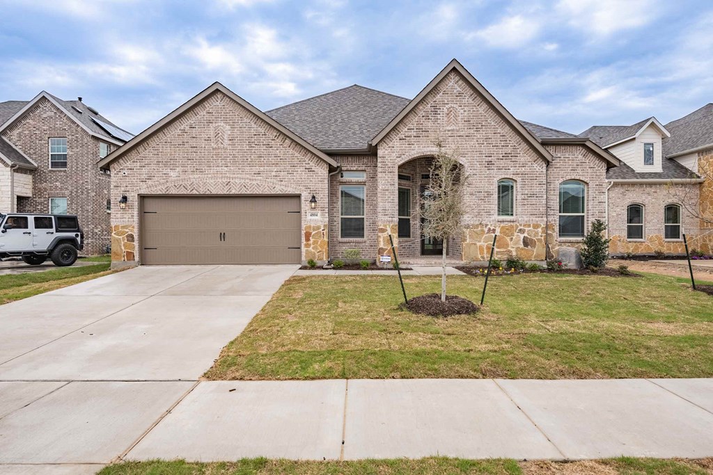 a new brick house with a brown garage door