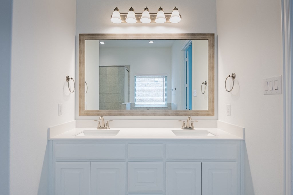 a bathroom with two sinks and a large mirror
