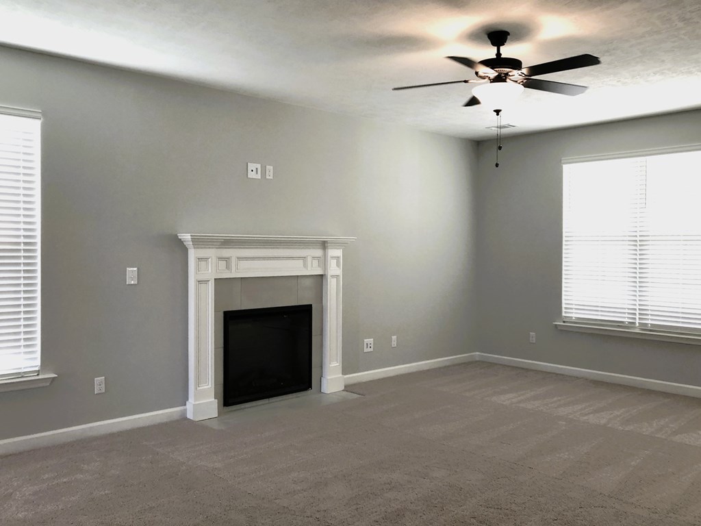 A room with a fireplace and a ceiling fan.
