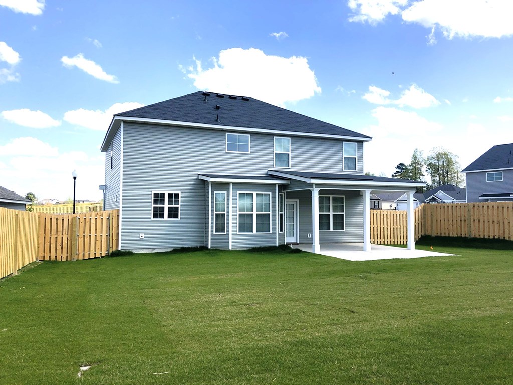 A house with a grey exterior and a wooden fence.