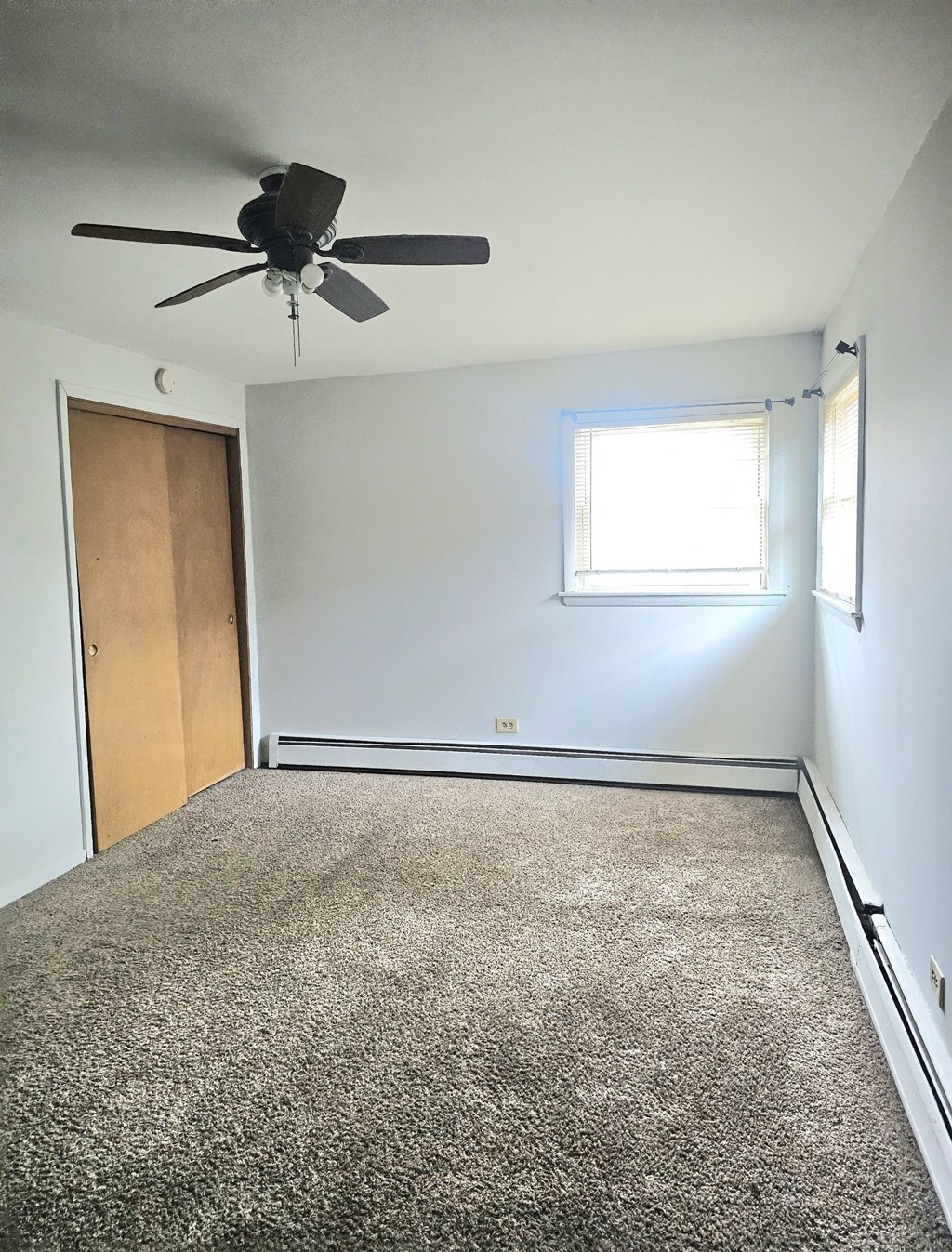 an empty room with a ceiling fan and a door
