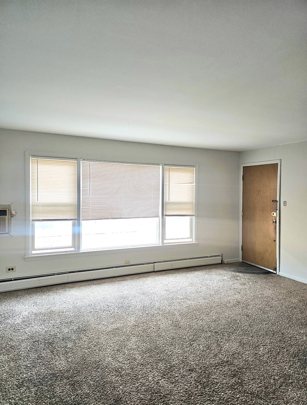 an empty room with a window and a door