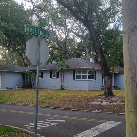 a house on the corner of west end street and a stop sign