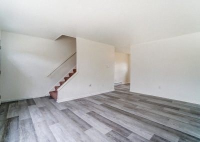a white room with a staircase and wood floors