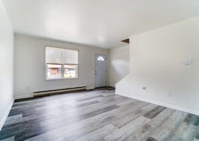 an empty living room with white walls and wood floors