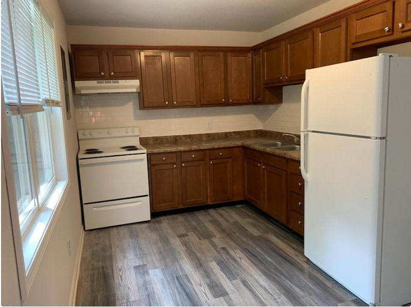a kitchen with white appliances and wooden cabinets