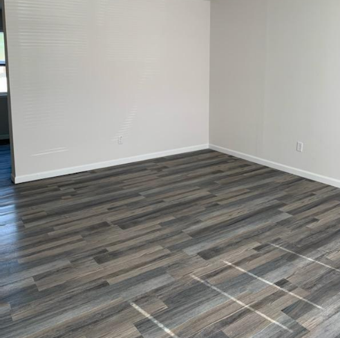 a room with a wooden floor and a white wall