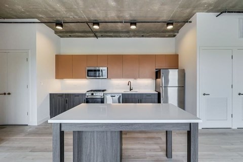 A modern kitchen with a table in the middle.