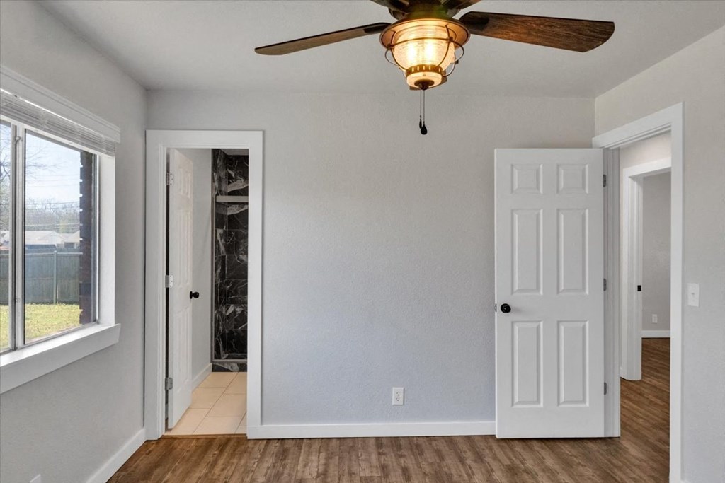 an empty room with a ceiling fan and a door to a closet