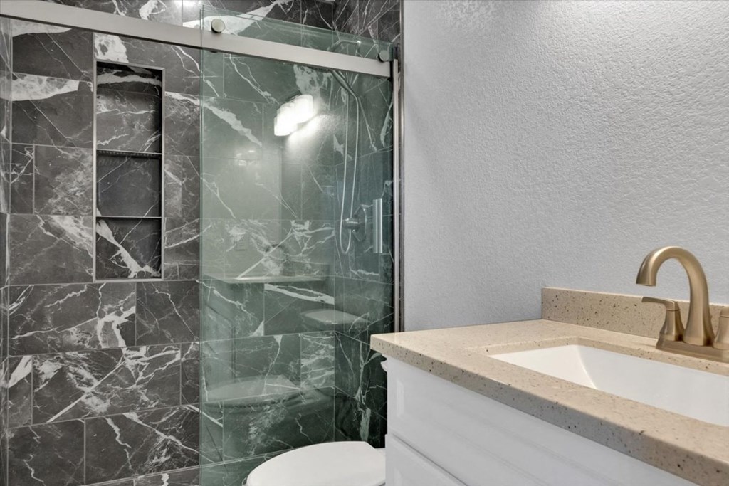 a bathroom with a sink and a shower and a toilet