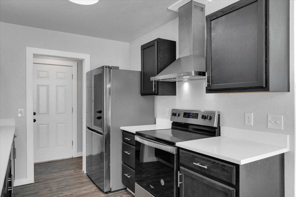 a kitchen with stainless steel appliances and black cabinets