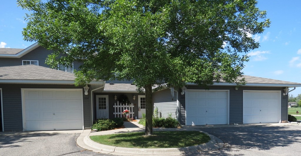 a house with two garage doors and a tree