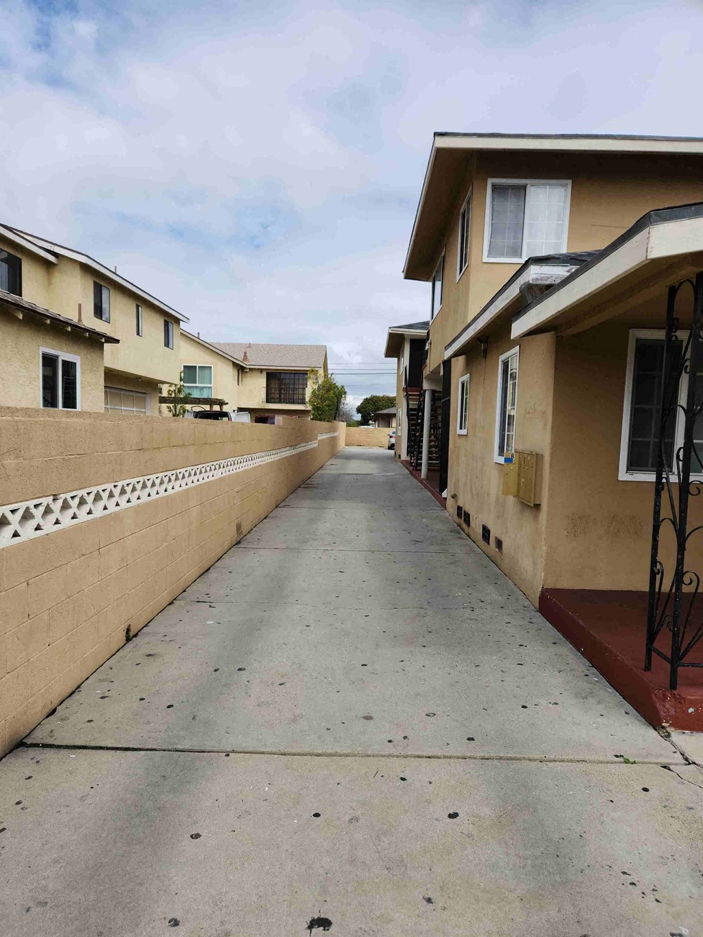 an empty alleyway between two buildings with a concrete sidewalk