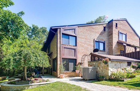 A house with a stone wall and a garden in front.