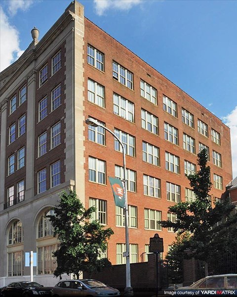 a tall brick building with a flag in front of it