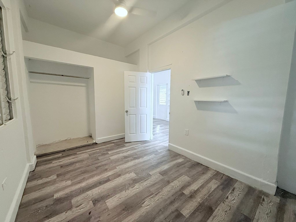 A room with wooden flooring and white walls.