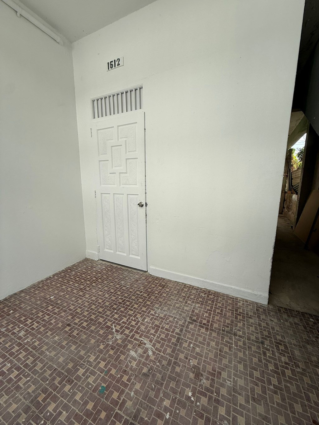 A room with a door and a tiled floor.