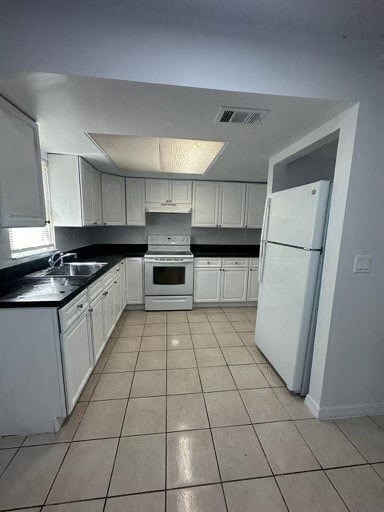a kitchen with white cabinets and a white refrigerator