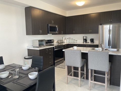 a kitchen and dining area with a table and chairs and a refrigerator