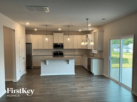 A kitchen with a white island and wooden floors.