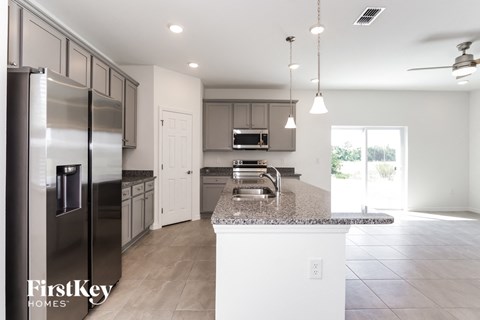 a large kitchen with stainless steel appliances and granite counter tops