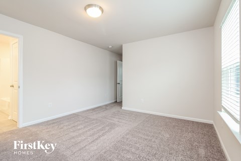 a spacious living room with white walls and a large window