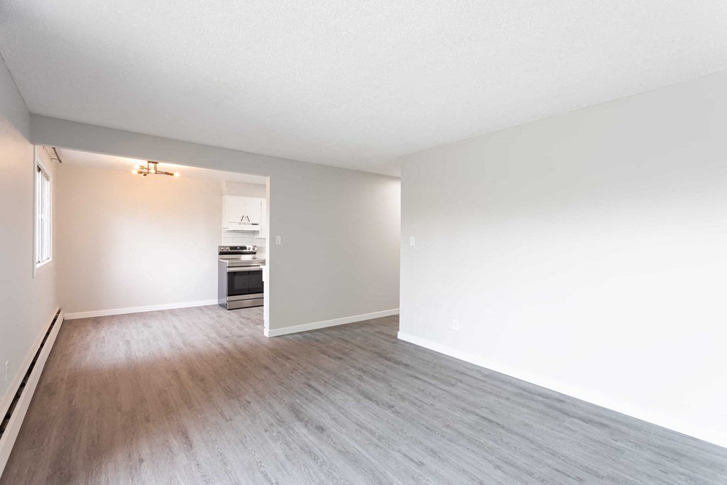 an empty living room with white walls and wood floors