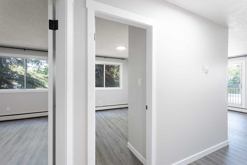 an empty living room with white walls and wood floors