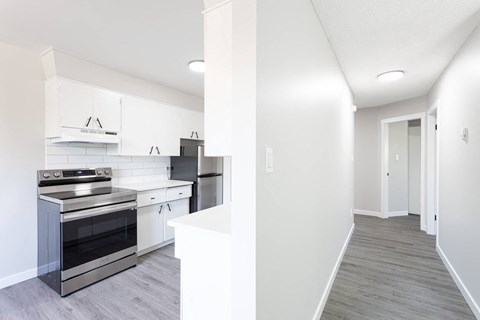 a renovated kitchen with white cabinets and black appliances