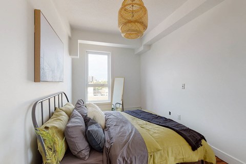 A bedroom with a bed and a window.