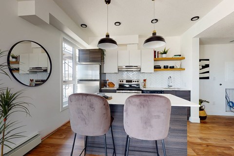 Two chairs are placed in front of a kitchen island.