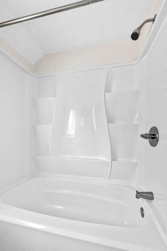 a white bathroom with a tub and a shower