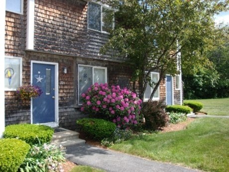 a house with a blue door and flowers in front of it