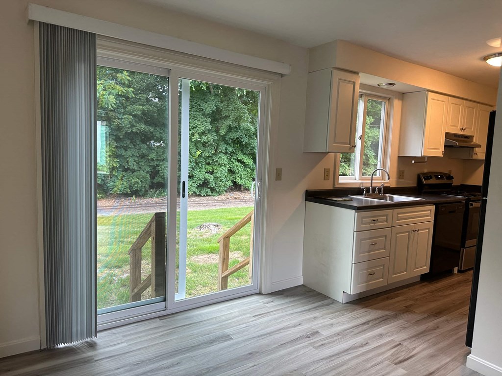 a kitchen with a sliding glass door overlooking a yard