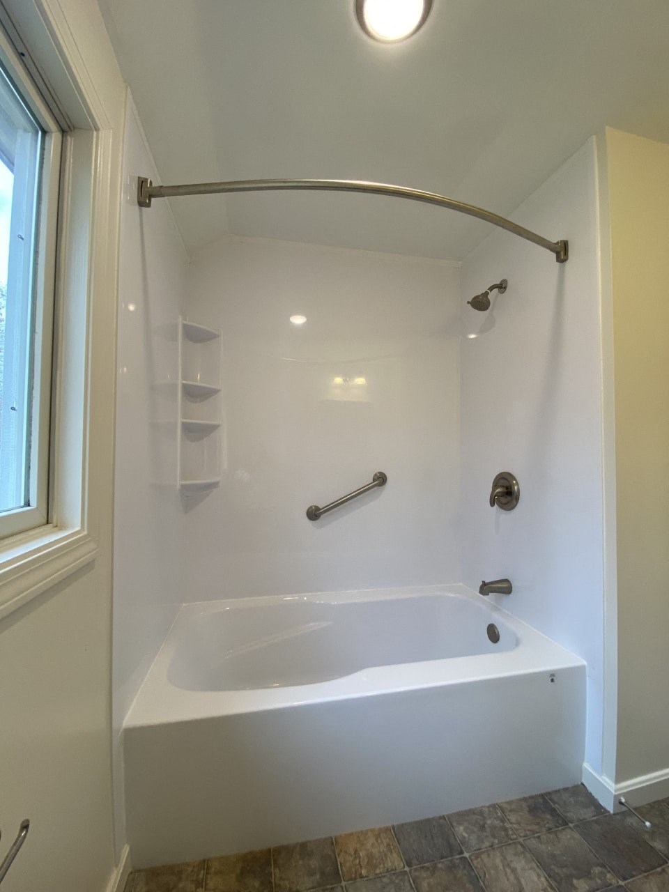 the master bathroom has a large tub and a window