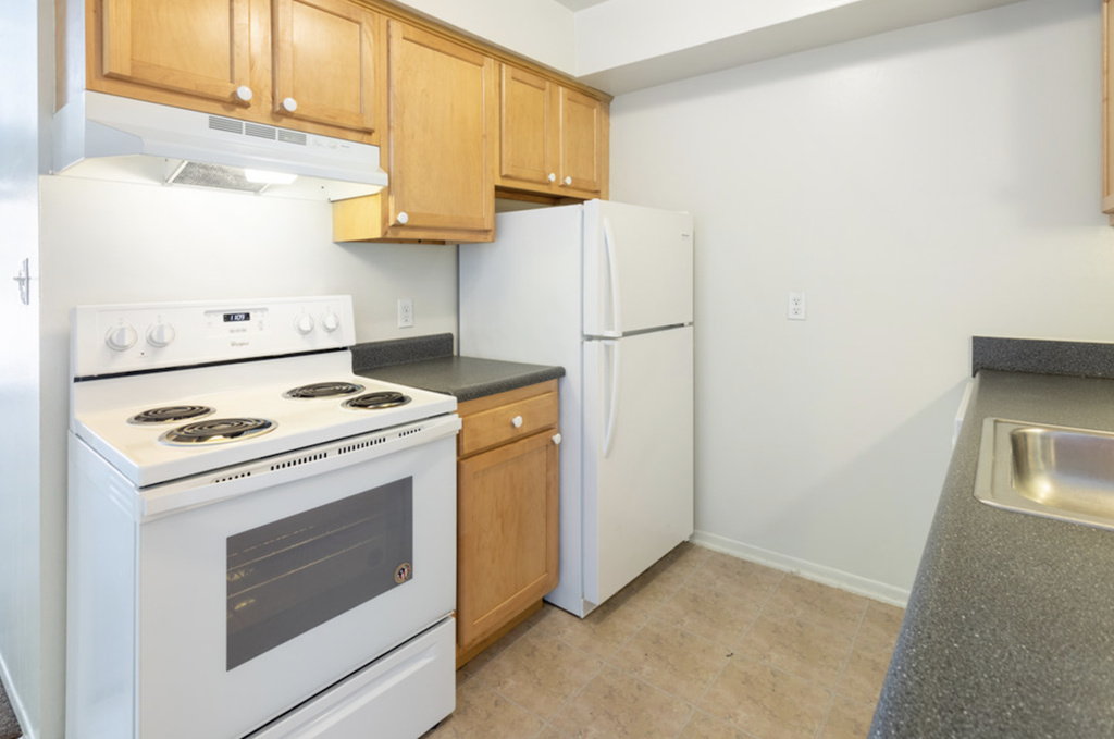 a kitchen with white appliances and wooden cabinets