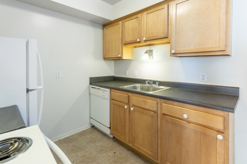 a kitchen with wooden cabinets and a sink and a refrigerator