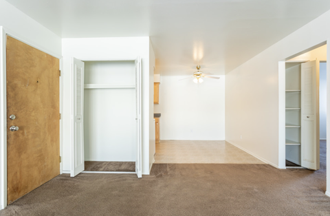 a empty living room with a door to a closet